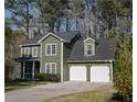 Traditional two-story home with attached two-car garage, manicured lawn and mature trees at 1320 Country Acres Ln, Lawrenceville, GA 30045