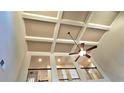 Dramatic view showcasing the coffered ceiling and ceiling fan in this light-filled living space at 5010 Lynnonhall Ct, Stonecrest, GA 30038