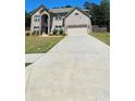 Traditional two-story brick home with an attached two-car garage and a long driveway at 5010 Lynnonhall Ct, Stonecrest, GA 30038