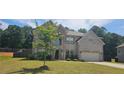 Charming two-story home with a brick facade, arched entryway, and lush green lawn at 5010 Lynnonhall Ct, Stonecrest, GA 30038