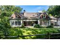Expansive backyard with a manicured lawn, mature trees, and a traditional-style home with large windows at 5360 Lake Forrest Dr, Atlanta, GA 30342