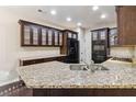 Modern kitchen with granite countertops, dark wood cabinets, and stainless steel appliances at 700 Ridgeway Ct, Canton, GA 30114