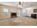 Open-concept living room featuring a cozy stone fireplace and seamless flow into dining area at 700 Ridgeway Ct, Canton, GA 30114
