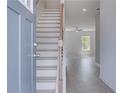 Inviting entryway with light wood stairs and luxury vinyl plank flooring throughout the main level at 110 Alpine Rd, Fairburn, GA 30213