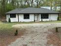 Newly renovated home with a modern exterior, dark roof, new windows, and gravel driveway at 12836 Cumming Hwy, Canton, GA 30115