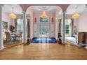 Elegant foyer with gleaming hardwood floors, decorative columns, and ornate chandeliers at 3018 Saint Andrews Ct, Jonesboro, GA 30236
