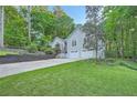Inviting front exterior showcases a two-car garage, manicured lawn and mature trees at 507 Falls Way, Woodstock, GA 30188
