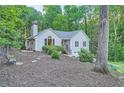 Back view of cozy house with landscaped yard, a serene setting, and a chimney at 507 Falls Way, Woodstock, GA 30188