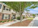 Attractive townhome showcasing a tree-lined street, brick accents, and well-maintained landscaping at 7244 Rockhouse Rd, Austell, GA 30168