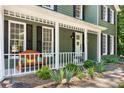 Cozy front porch with inviting bench seating, decorative plants, and charming curb appeal at 1027 Spring Mill Sw Dr, Lilburn, GA 30047