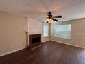 Spacious living room featuring a fireplace, ceiling fan, and hardwood floors at 3836 Wexford Dr, Douglasville, GA 30134