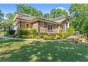 Brick home featuring a lush green lawn and mature trees at 5816 Chamblee Dunwoody Rd, Atlanta, GA 30338