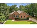 Charming brick home featuring an arched entry, manicured landscaping and a lush green lawn at 7940 Gable Dr, Douglasville, GA 30135