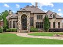 Stately stone home featuring a manicured lawn and stone walkway at 878 Middle Fork Trl, Suwanee, GA 30024