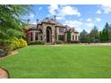 Expansive front lawn and stone exterior on a bright, sunny day at 878 Middle Fork Trl, Suwanee, GA 30024