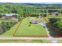 Expansive property with a well-maintained home, surrounded by lush greenery and defined by red property lines at 24 Fossetts Nw Cv, Cartersville, GA 30121