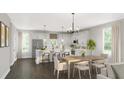 Open-concept kitchen/dining featuring stainless steel appliances, island, and lovely light fixtures at 2733 Creek View Nw Ter, Atlanta, GA 30318