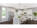 Bright kitchen features stainless steel appliances, white cabinets, and spacious island with seating at 2733 Creek View Nw Ter, Atlanta, GA 30318