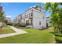 Townhome exterior view with manicured lawn and sidewalks, offering a contemporary aesthetic at 1030 Burnside Nw Pl, Atlanta, GA 30318