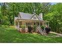 Cozy home featuring a covered porch, mature trees, and a meticulously manicured front yard at 3845 Pilgrim Mill Rd, Cumming, GA 30041