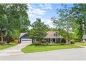 Charming two-story home with lush green lawn, mature trees, and a driveway leading to an attached garage at 209 Hearthstone Reach, Peachtree City, GA 30269