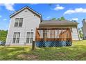 Home's backyard featuring a wooden deck, a lush lawn, and a peaceful outdoor space at 9511 Rollinghills Dr, Jonesboro, GA 30238