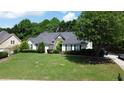 Well-maintained home features a green lawn, manicured bushes, and a classic front facade at 260 Ruby Forest Pkwy, Suwanee, GA 30024