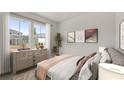 Bright bedroom showcasing a large window, a dresser with decor, and modern art pieces at 3178 Birdsong Ave, Covington, GA 30016