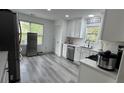 Modern kitchen features all-white cabinetry, stainless steel appliances, quartz countertops, and gray wood-look flooring at 51 Freedom Ne Dr, Cartersville, GA 30121