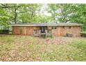 A backyard featuring a small, aged wooden deck and a full brick home exterior at 1443 Snapfinger Rd, Decatur, GA 30032