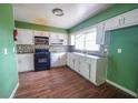 A kitchen featuring black appliances, white cabinetry and a mosaic tile backsplash at 1443 Snapfinger Rd, Decatur, GA 30032