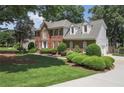 Beautiful brick home with manicured landscaping, lush green lawn, and a side-entry garage at 1915 Milfield Cir, Snellville, GA 30078