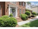 Inviting brick front porch with meticulously maintained bushes and a grey front door at 1915 Milfield Cir, Snellville, GA 30078