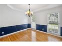 Bright dining room featuring hardwood floors, wainscoting, and a decorative chandelier at 2350 Twelvestones Dr, Roswell, GA 30076