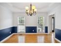 Sunlit dining room featuring hardwood floors, wainscoting, and two large windows at 2350 Twelvestones Dr, Roswell, GA 30076