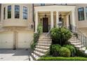 A detailed view of the home's entrance, showcasing manicured landscaping, an elegant staircase, and a covered porch at 122 Old Ivy Ne Rd # 17, Atlanta, GA 30342