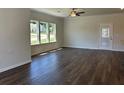 Open-concept living room with three large windows, hardwood floors, recessed lighting, and neutral paint at 3706 Cheswolde Ave # 96, Powder Springs, GA 30127