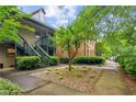 Exterior view of a multi-story condo building featuring a well maintained lawn, landscape, and stairs to the units at 721 Beaufort Cir, Duluth, GA 30096