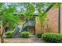 Attractive condo building featuring stairs, a covered porch, and well maintained landscape in a suburban setting at 721 Beaufort Cir, Duluth, GA 30096