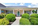 Inviting front porch with a stylish teal door, decorative wreath, and manicured landscaping at 102 Autumn Brooke Trl, Dallas, GA 30157