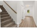 View of a home entryway with stairs, wood flooring, white walls, and a view to the front door at 206 Sharon Ln, Loganville, GA 30052