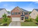 Beautiful two-story brick home featuring a two-car garage, a well-maintained lawn, and mature trees at 3825 Sycamore Hill Dr, Loganville, GA 30052