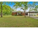 Charming brick home with well-maintained lawn, covered carport, and mature trees at 7783 Cantrell Rd, Douglasville, GA 30135