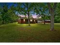 Wide view of a brick home with well-maintained lawn, mature trees and covered carport at 7783 Cantrell Rd, Douglasville, GA 30135