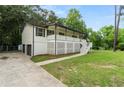 Inviting exterior featuring a white lattice-covered porch, a driveway leading to the garage, and green landscaping at 4170 Maroney Mill Rd, Douglasville, GA 30134