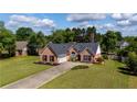 Beautiful aerial shot of the brick home and expansive green lawn on a bright, sunny day at 7095 Valley Landing Ct, Cumming, GA 30041