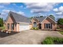 Lovely brick home featuring an attached two-car garage and ample driveway space at 7095 Valley Landing Ct, Cumming, GA 30041