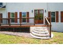 Front entrance boasts brick steps leading to a wooden deck, framed by double doors and shuttered windows at 17 Hiram Way, Hiram, GA 30141