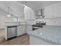 Modern kitchen featuring white cabinets, stainless steel appliances, and stone countertops at 194 Beaverwood Ct, Lawrenceville, GA 30044