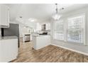 Well-lit kitchen with white cabinets, stainless steel appliances, granite countertops and hardwood floors at 194 Beaverwood Ct, Lawrenceville, GA 30044